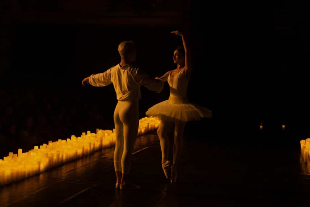 Photo de deux danseurs de ballets performant pour un concert Candlelight entourés de bougies