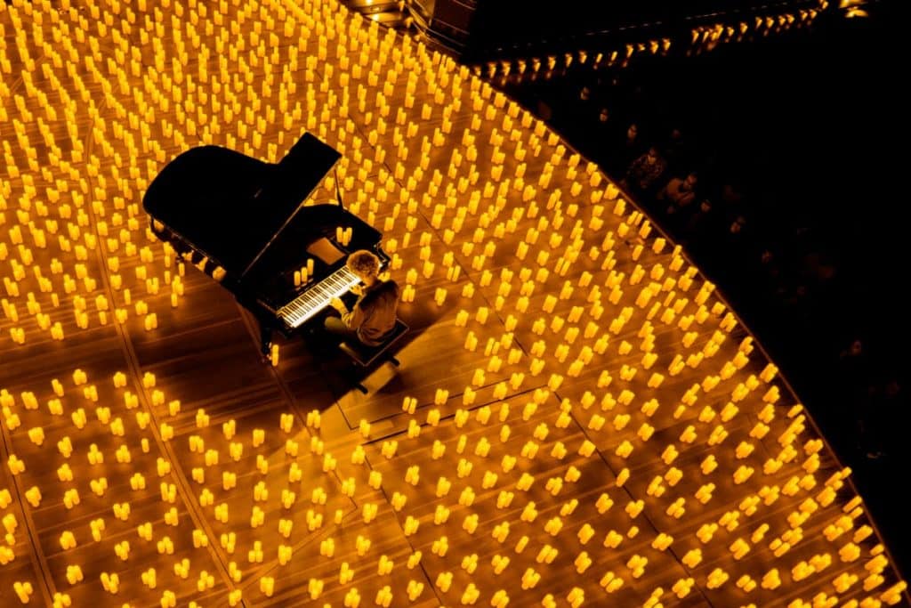 Concert Candlelight au piano vu de haut avec une scène remplie de bougies et un pianiste au centre